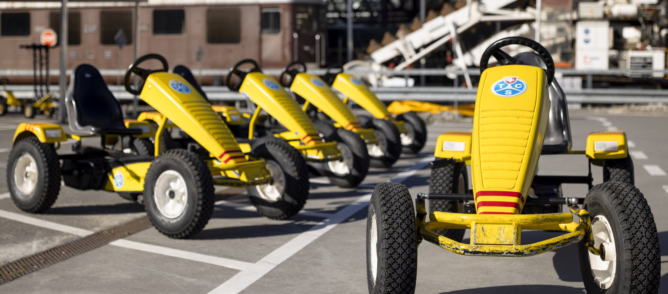 Gelbe Gokarts stehen in einer Reihe draussen in der Verkehrshausarena.