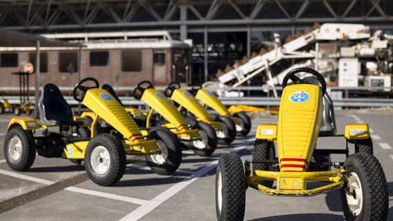 Gelbe Gokarts stehen in einer Reihe draussen in der Verkehrshausarena.