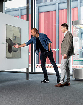 Zwei Besucher bestaunen die verschiedenen Werke der Exhibition.