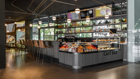 Eine Café Bar mit Theke und Barhockern und Snacks. 