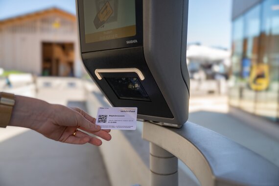 Ein Ticket wird an einem Drehkreuz gescannt.