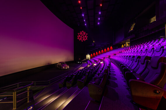 Leeres Filmtheater mit pinkfarbener Beleuchtung.