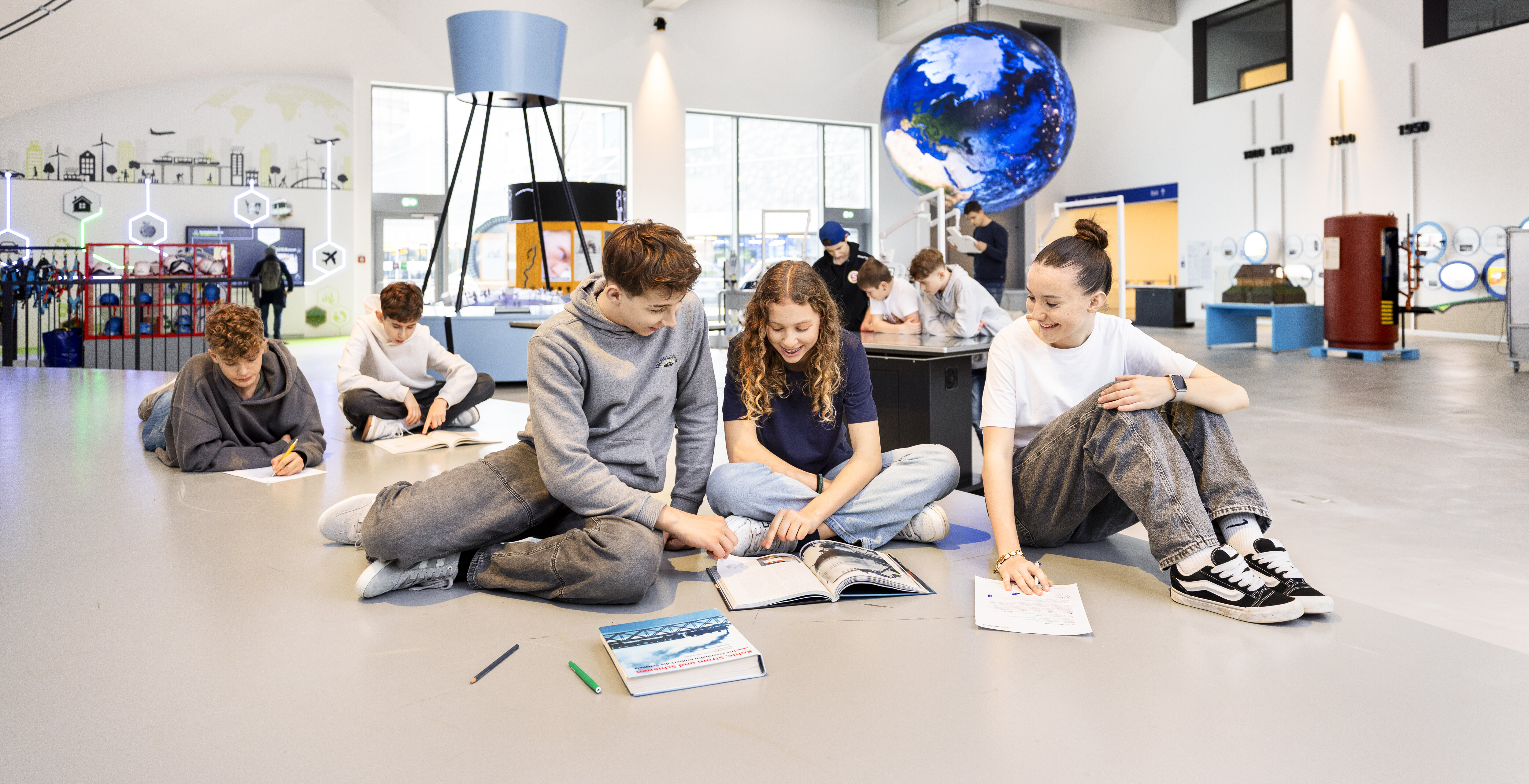 Eine Gruppe von Schüler löst Arbeitsblätter im Verkehrshaus.