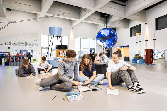 Eine Gruppe von Schüler löst Arbeitsblätter im Verkehrshaus.