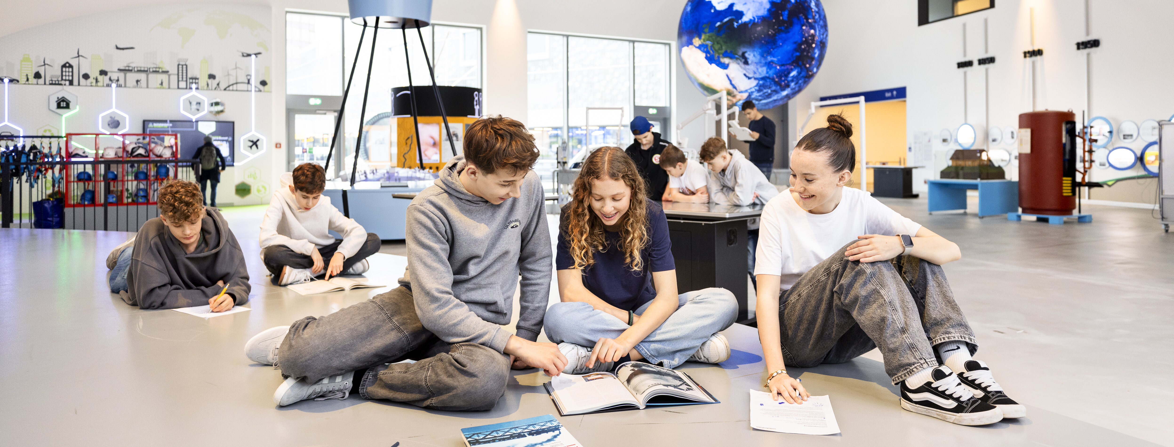 Eine Gruppe von Schüler löst Arbeitsblätter im Verkehrshaus.