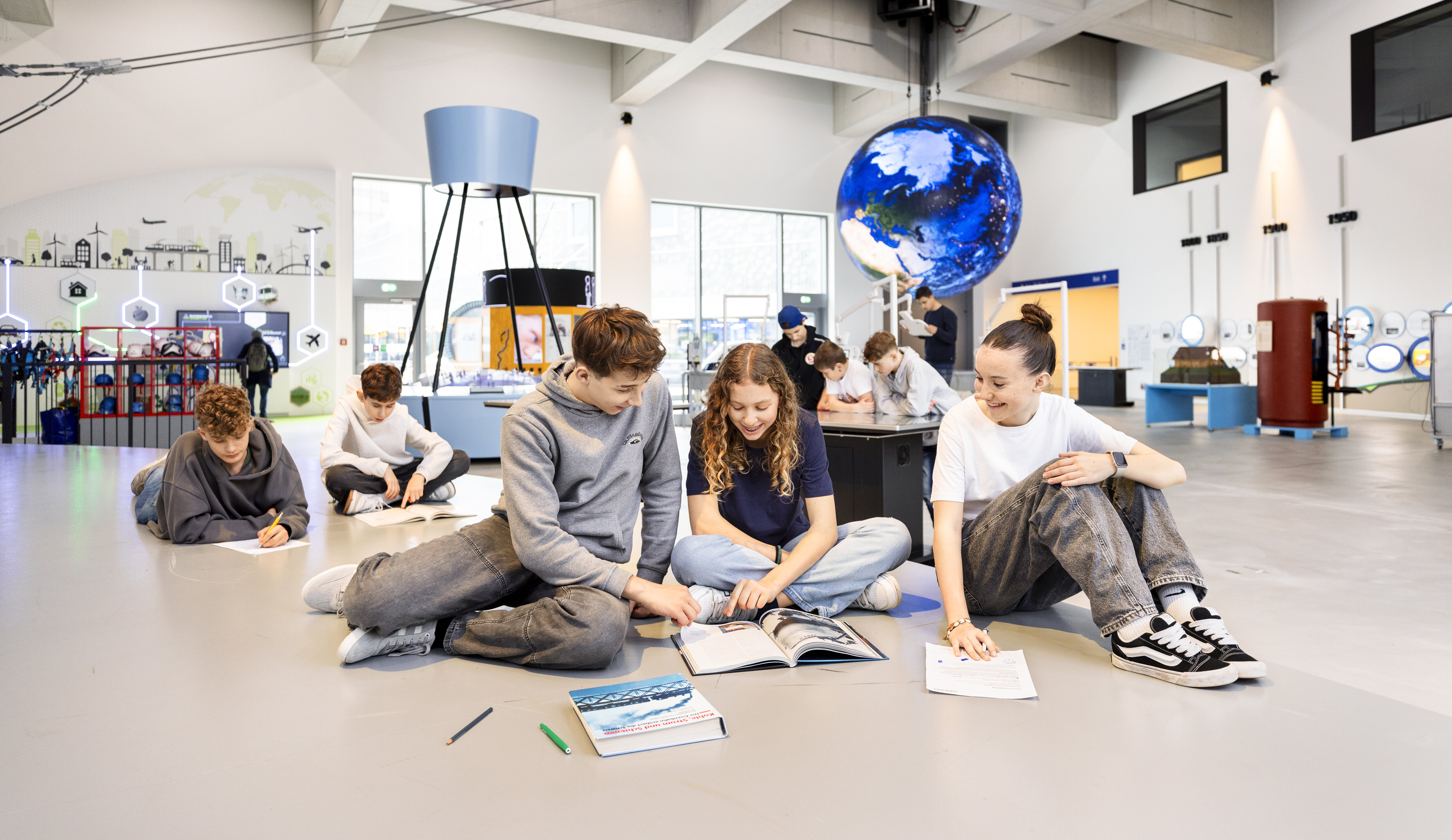 Eine Gruppe von Schüler löst Arbeitsblätter im Verkehrshaus.