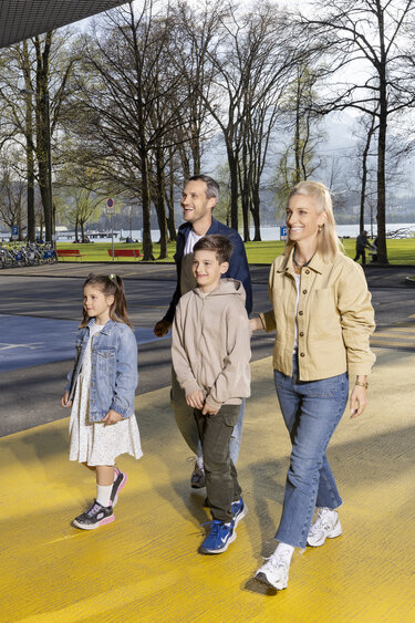 Eine vierköpfige Familie läuft ins Verkehrshaus der Schweiz. 