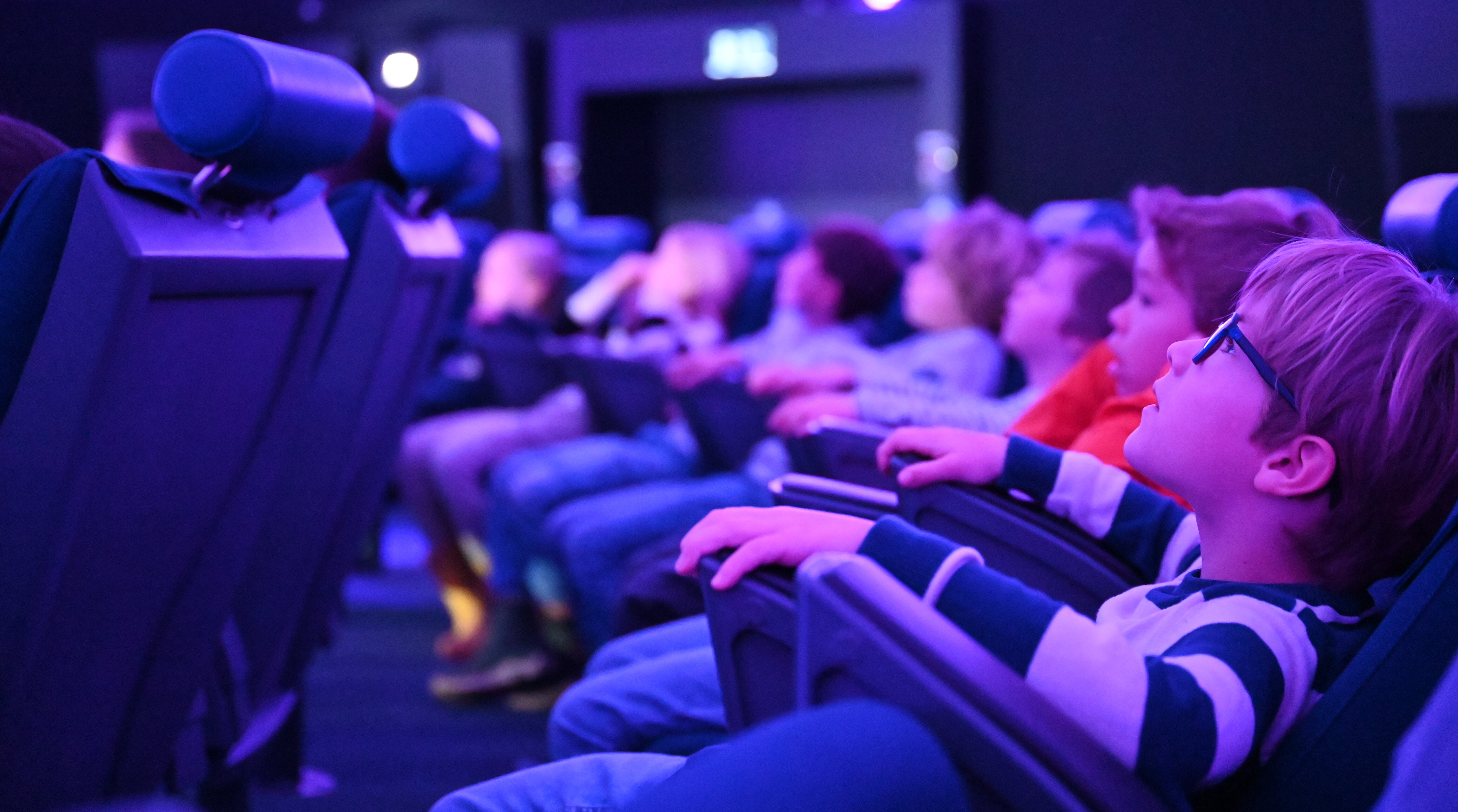 Ein Junge blickt in den Sternenhimmel des Planetariums im Verkehrshaus der Schweiz.