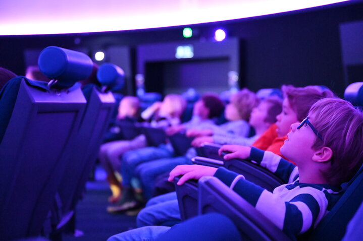 Ein Junge blickt in den Sternenhimmel des Planetariums im Verkehrshaus der Schweiz.