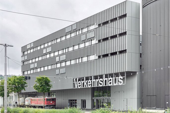 Ein graues Gebäude mit drei Fensterreihen und der Aufschrift Verkehrshaus.