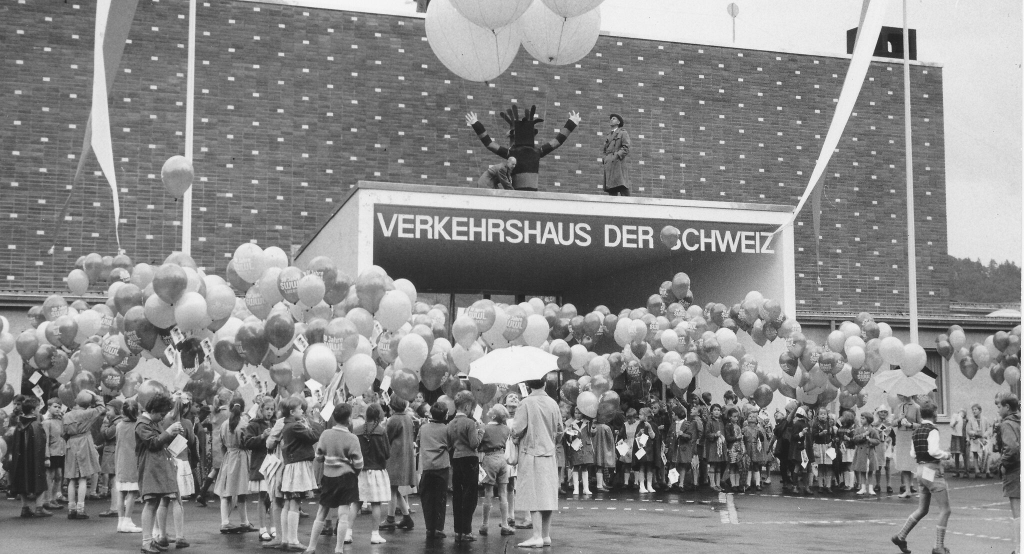 Das Verkehrshaus der Schweiz feiert seine Eröffnung mit einer grossen Menschenmenge und Luftballons.