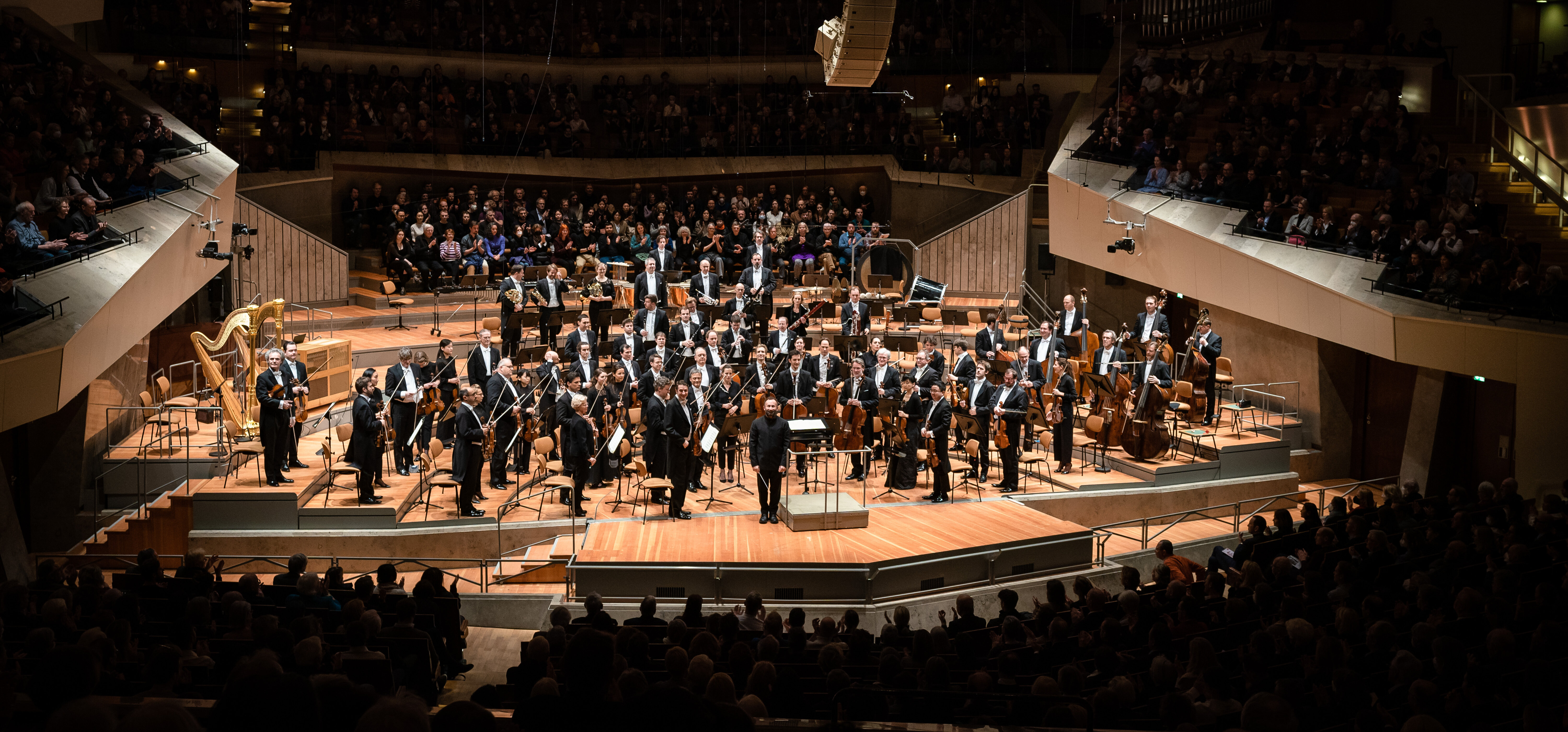 Ein Orchester auf einer Bühne in einem Konzertsaal.