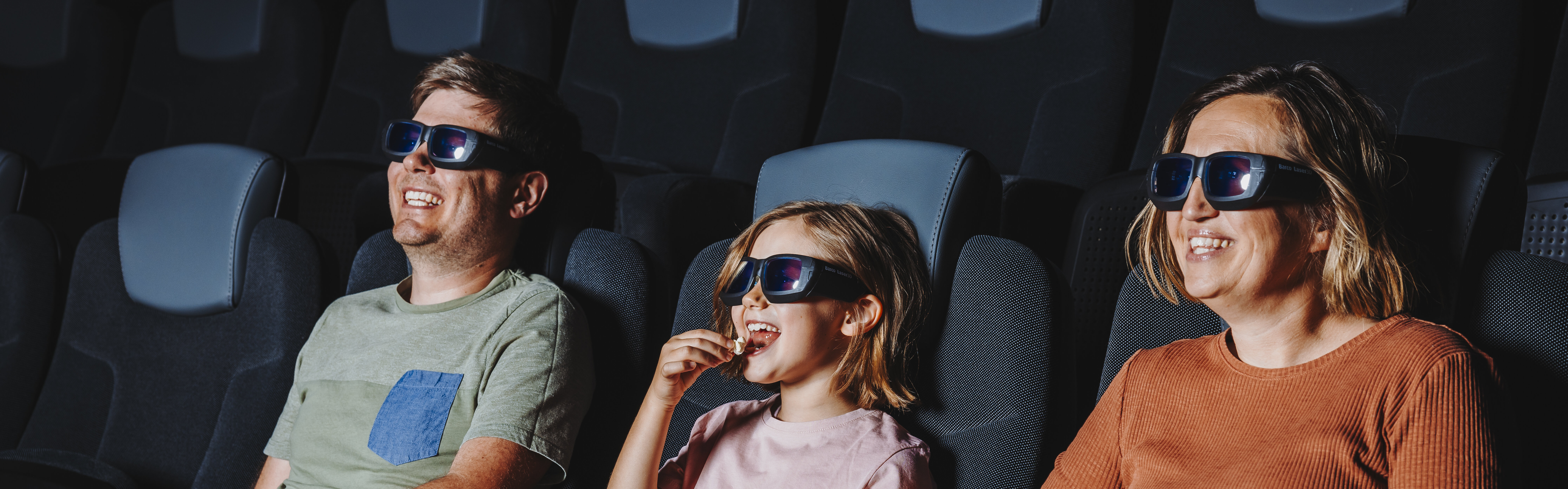 Eine dreiköpfige Familie im Verkehrshaus Filmtheater.