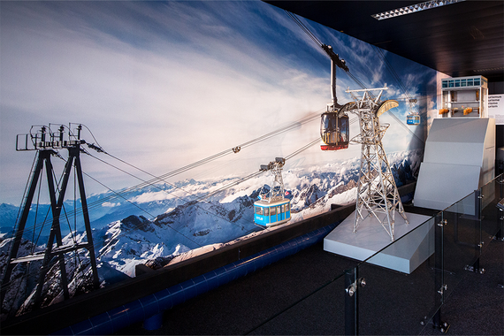 Ein Modell einer Seilbahn vor der Kulisse schneebedeckter Berge, das das Seilbahnsystem eines Skigebiets zeigt.