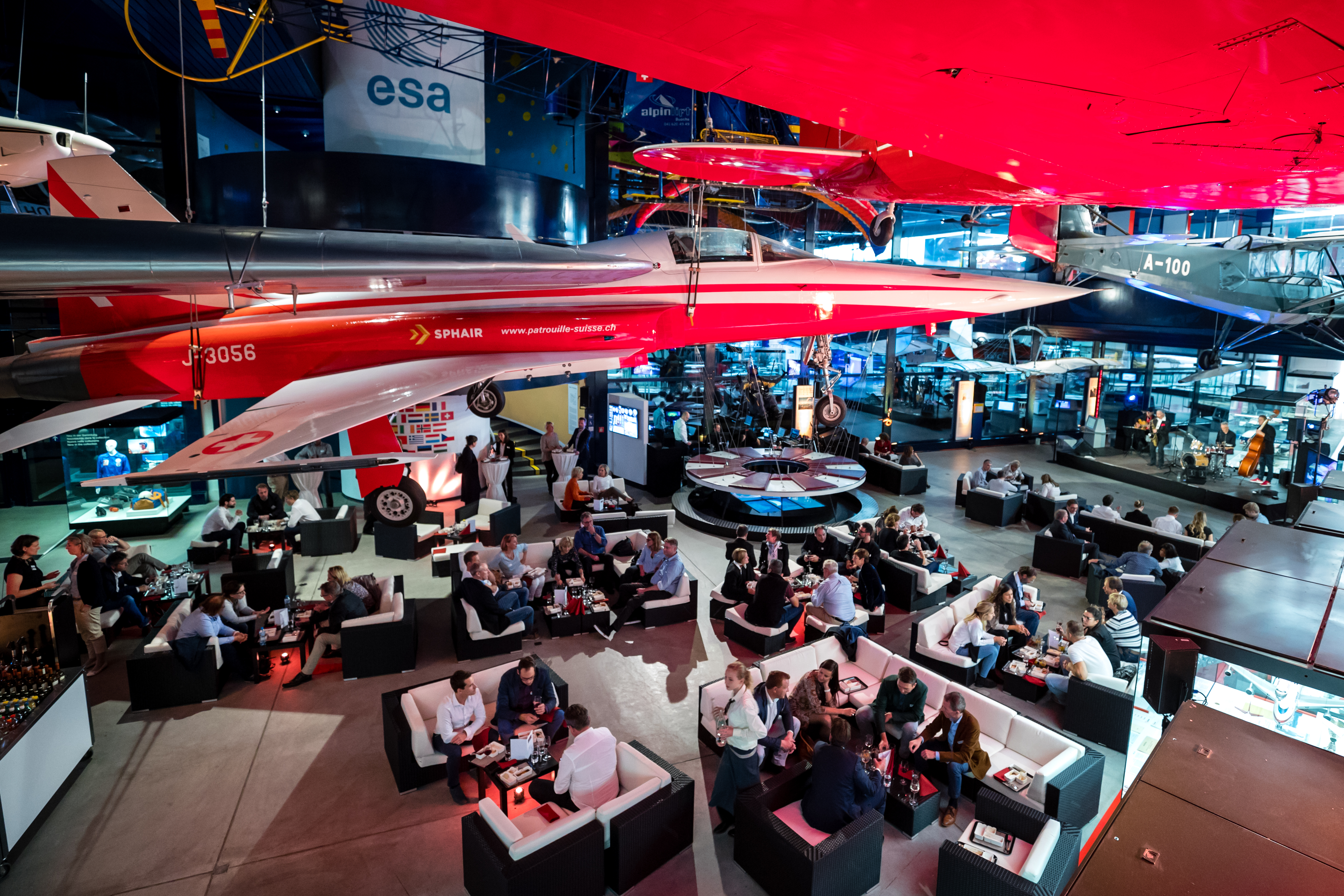 Viele Leute sitzen auf Lounges unter den Fliegern in der Halle Luft- und Raumfahrt.